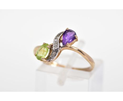 A 9CT GOLD AMETHYST AND PERIDOT RING, of crossover design set with a pear cut amethyst and peridot interspaced by single cut 