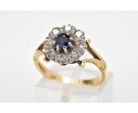 A SAPPHIRE AND DIAMOND CLUSTER RING, designed as a central circular blue sapphire within a brilliant cut diamond surround to 