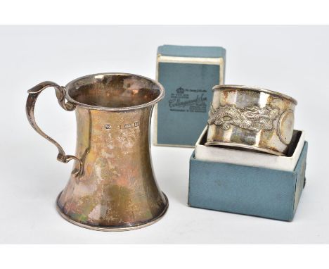 AN EARLY 20TH CENTURY SILVER CHRISTENING MUG AND A CHINESE NAPKIN RING, the christening mug of waisted design with scrolling 