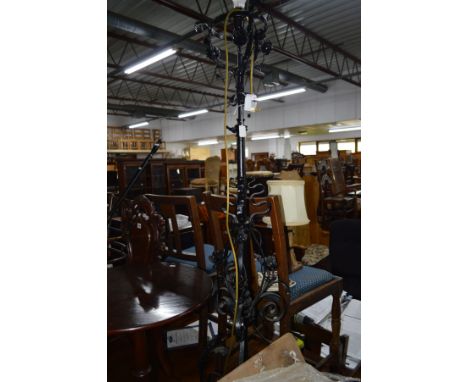 A 20TH CENTURY BLACK GROUND WROUGHT IRON TELESCOPIC STANDARD LAMP with foliate and scrolled decoration and a fabric shade and