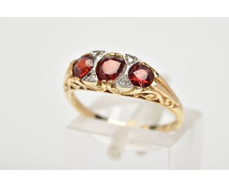 A 9CT GOLD GARNET AND DIAMOND RING, with three graduated circular cut garnets interspaced with round brilliant cut diamonds, 