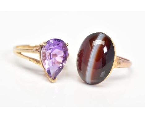 TWO GEM SET RINGS, the first set with an oval agate cabochon, stamped 9ct, ring size O, the second a pear shape amethyst in a