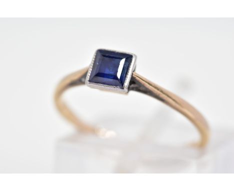 A SAPPHIRE RING, designed with a central square cut sapphire in a milegrain setting to the tapered shoulders, stamped 9ct, ri