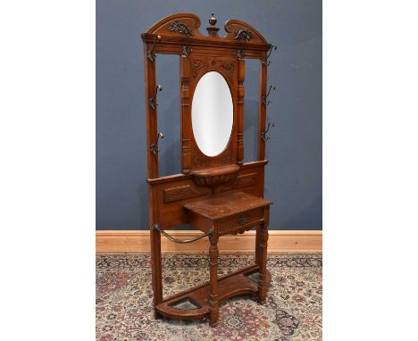 A Victorian carved walnut hall stand, with central bevelled plate above single drawer flanked by stick compartments, height 1