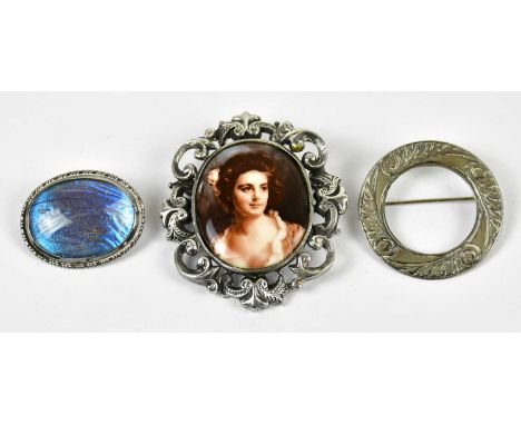 Two sterling silver brooches, one with a printed portrait of a maiden, together with a further brooch stamped 'Silver'.