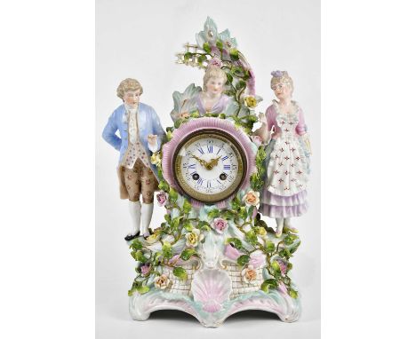 An early 20th century Continental porcelain figural mantel clock representing two maidens and a male beside the enamel dial s