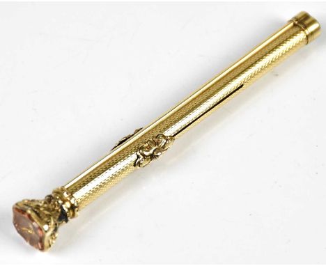 A Victorian yellow metal propelling pen/pencil with engine turned decoration and amber coloured stone terminal, length 9cm.