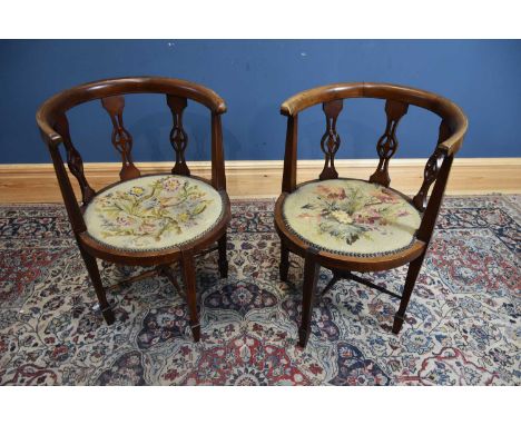 A pair of Edwardian inlaid mahogany corner chairs with tapestry seats.