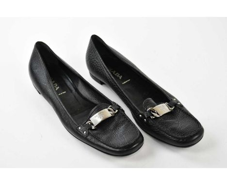 PRADA; a pair of black pebbled leather flat court shoes, embellished with silver tone buckle with maker's logo to front, size