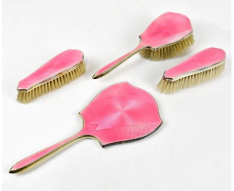 DANIEL MANUFACTURING COMPANY; a George V hallmarked silver and pink guilloche enamel four piece dressing table set comprising