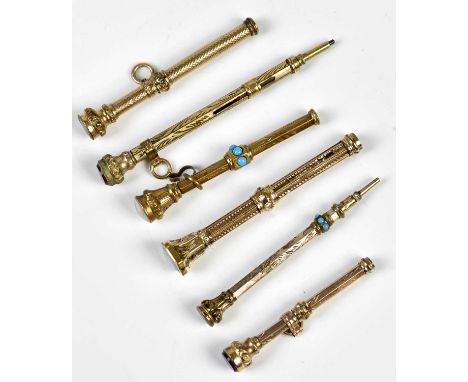 Six late Victorian yellow metal propelling pencils, with chased/engine turned decoration, and hardstone/glass terminals, leng