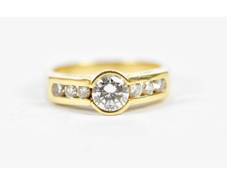 A yellow metal diamond set ring, the principal round brilliant cut stone weighing approx 1ct, with six small round brilliant 