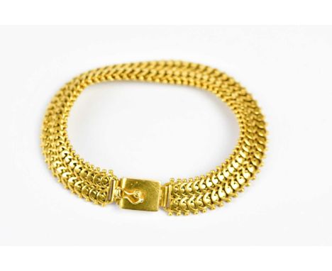 An Eastern yellow metal bracelet with cast decoration, unmarked, approximate weight 51.8g.Condition Report: Although unmarked