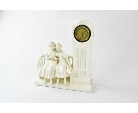 A French Blanc de Chine figural mantel clock representing two children seated on a bench beside a longcase clock, with gilt d