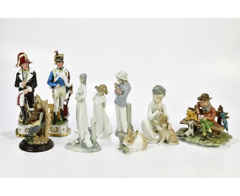 LLADRÓ; a model of a child seated beside a puppy, height 19cm, Nao model of a girl, Nao model of a boy holding a puppy, Capod