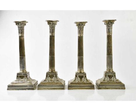 JAMES DIXON &amp; SONS; a near set of four Edward VII hallmarked silver Corinthian column candlesticks, with cast scrolling d