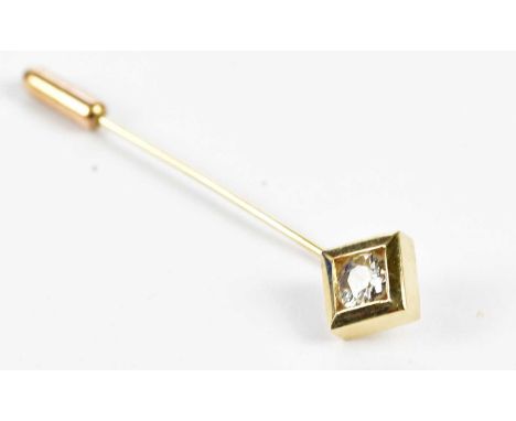 A yellow metal stick pin with collet set round brilliant cut diamond weighing approx. 0.60cts, length 55mm, approx. 3.1g. 