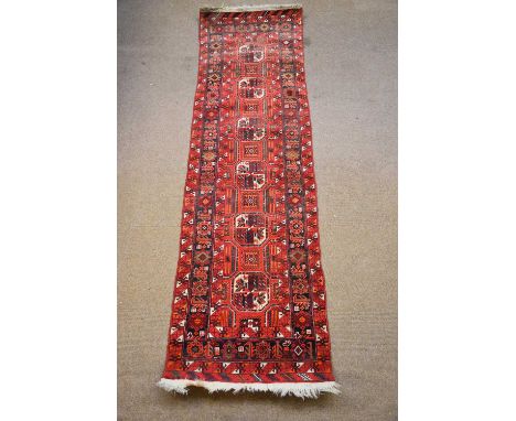 A Caucasian hand woven wool runner, worked with geometric detailing against a red ground, 355 x 84cm.Condition Report: Wear t