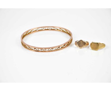 A 9ct yellow gold bangle with openwork decoration, approx 10g, and a 9ct yellow gold gentleman's signet ring with engraved in