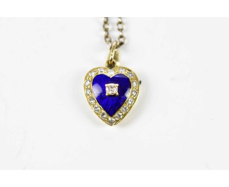 An 18ct yellow gold heart shaped pendant centred with a round brilliant cut diamond on a blue enamelled heart and border of s