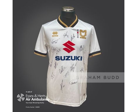 MK Dons 2020-21 season replica shirt personally signed in black marker to the front by 18 members of the playing squad. Comes