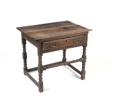 An 18th Century oak side table, the rectangular moulded top over a single frieze drawer, raised on bobbin-turned legs united 