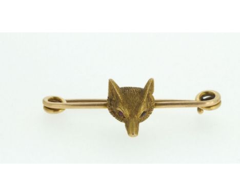 A 15 carat gold fox head bar brooch or stock pin set ruby eyes, 4cm wide , 4g
