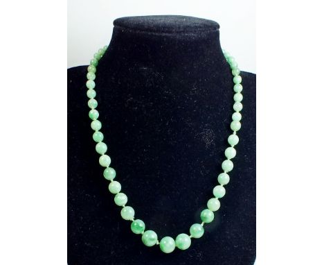 A string of jade beads with 18 carat white gold diamond set clasp 42cm