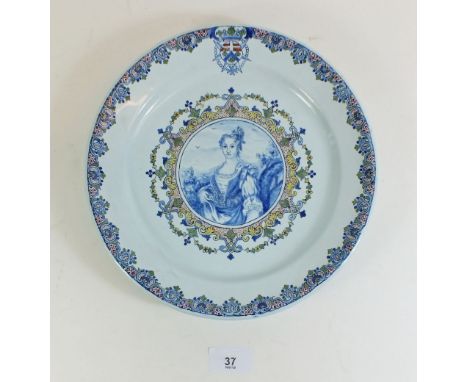 A 19th century continental Faience plate painted portrait of a Queen within floral and foliate border, monogram DG, 25cm diam