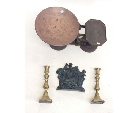 A set of kitchen scales, brass candlesticks and a door stop