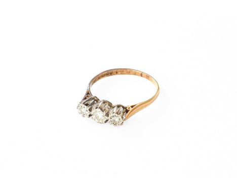 An 18 Carat Gold Diamond Three Stone Ring, the graduated round brilliant cut diamonds in white illusion settings, to a yellow