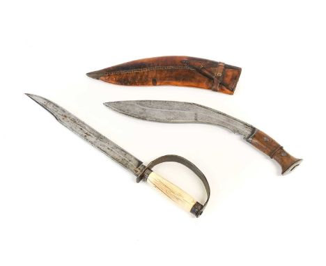 A Nepalese Kukri, the 32.5cm single edge curved steel blade with a narrow fuller to the back edge, the ricasso crudely engrav