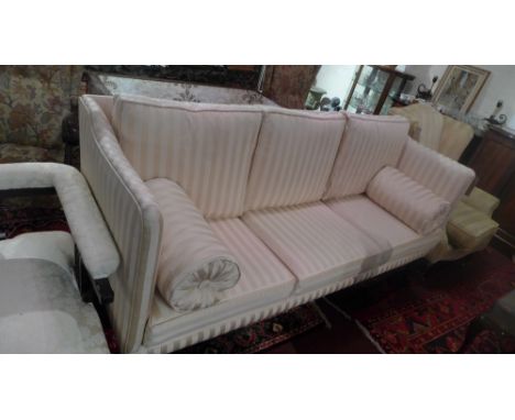 A regency style mahogany three seater sofa with stripped cream upholstery raised on tapered legs and castors.