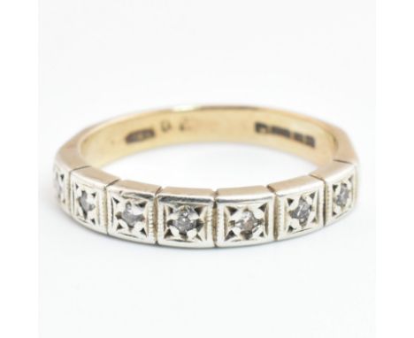 A hallmarked 9ct gold and diamond half eternity ring. The 9ct yellow gold half eternity ring having seven illusion set eight 