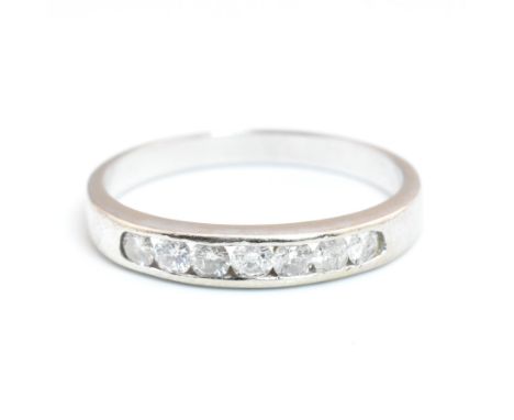 A hallmarked 9ct white gold and diamond half eternity ring. The 9ct white gold ring having seven channel set round brilliant 