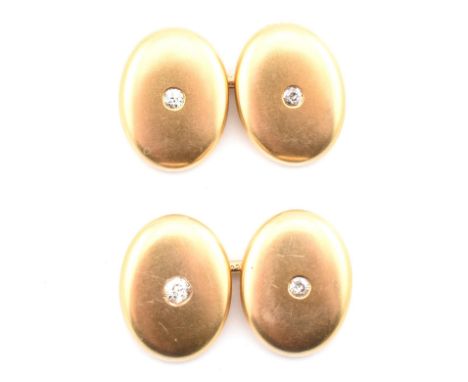 A pair of 14ct gold and diamond cufflinks. The 14ct gold bar link cufflinks having polished oval heads each set to the centre