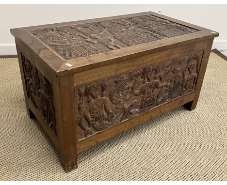 A 20th Century Indonesian carved camphor wood trunk, the top with central panel depicting various figures in ceremonial dress