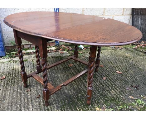 A mid 20th Century oak oval gate-leg drop-leaf dining table on barley-twist supports, three Georgian style cabriole leg stool