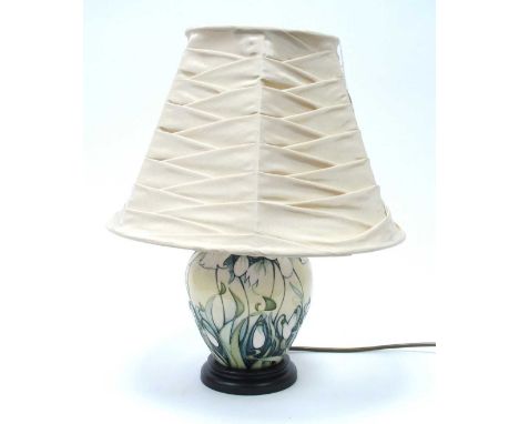 A Moorcroft table lamp decorated in the 'Snowdrop' pattern designed by Rachel Bishop, on wooden base, approx. 43cm high to sh