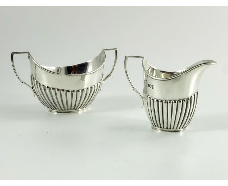 A Victorian silver milk jug and sugar basin, William Hutton, London 1896, half reeded boat form with angled handles, 7.5cm hi