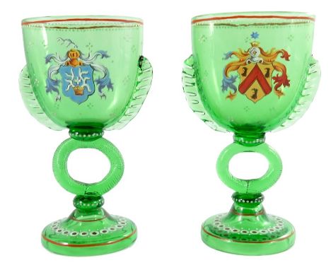 A pair of German enamelled glass marriage drinking glasses, flattened twin handled cup form on twisted ring stems, each with 