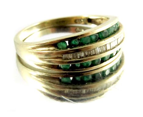 A diamond and emerald ring, in 9 carat gold, channel set with a central band of baguette diamonds, approx. size M