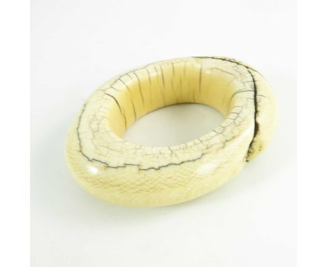 An antique ivory tribal bangle, possibly West of Central African, circa 19th century, of oval form, cracks and fissures, 12 x