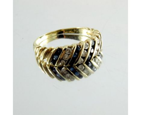 A diamond and sapphire ring, set in gold, alternating channels of three stones, approx. size M