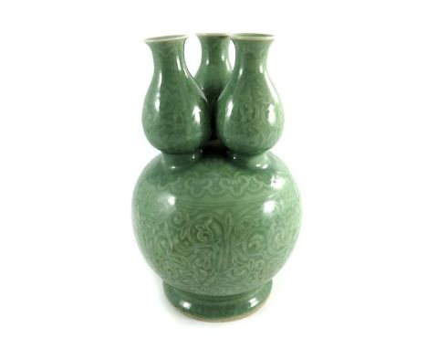 A Chinese celadon ground triple necked gourd vase, ovoid form with baluster necks, carved with foliate scroll design, 29cm hi