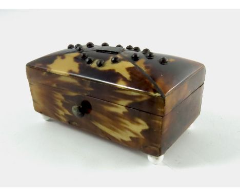 A 19th century miniature tortoiseshell and silver strung box, of tea caddy form, studded with silver, on four enamelled ball 