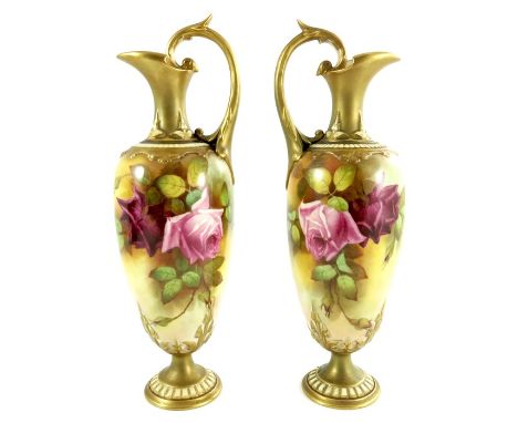 F Harper for Royal Worcester, a pair of rose painted ewers, 1919, ovoid pedestal form with relief moulded and gilded handles,