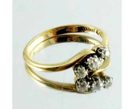A three stone diamond ring, on 18 carat gold band, approx. size J 1/2