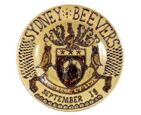 A studio pottery slipware charger, in the style of Thomas Toft, tubelined with a central coat of arms for Leeds and name Sydn