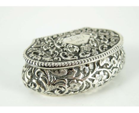 An Edwardian silver snuff box, Henry Matthews, Birmingham 1902, cushioned shell form, embossed in relief with foliate scroll 